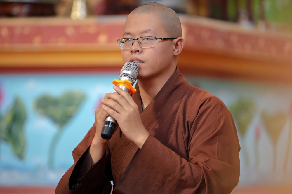 A person wearing glasses and a robe holding a microphone

AI-generated content may be incorrect.