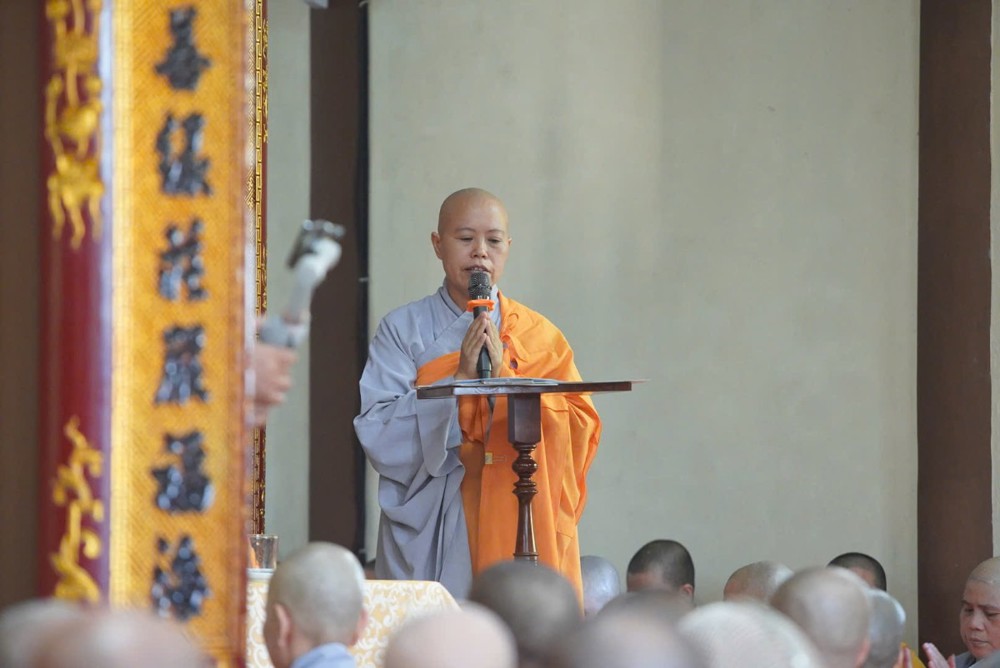 A monk in a robe speaking into a microphone

AI-generated content may be incorrect.