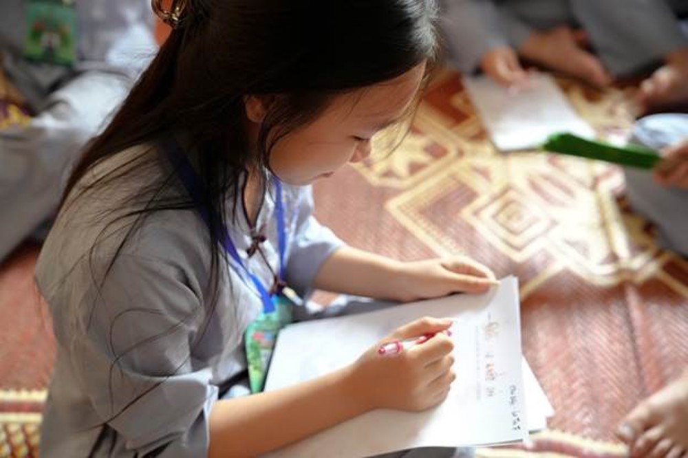 A young child writing on a piece of paper

AI-generated content may be incorrect.