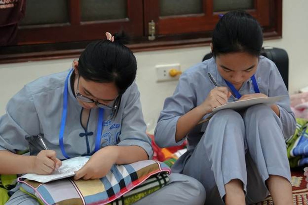 A couple of young women writing on a notebook

AI-generated content may be incorrect.