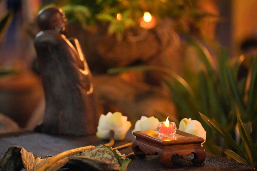 A small statue with a candle on a table

AI-generated content may be incorrect.