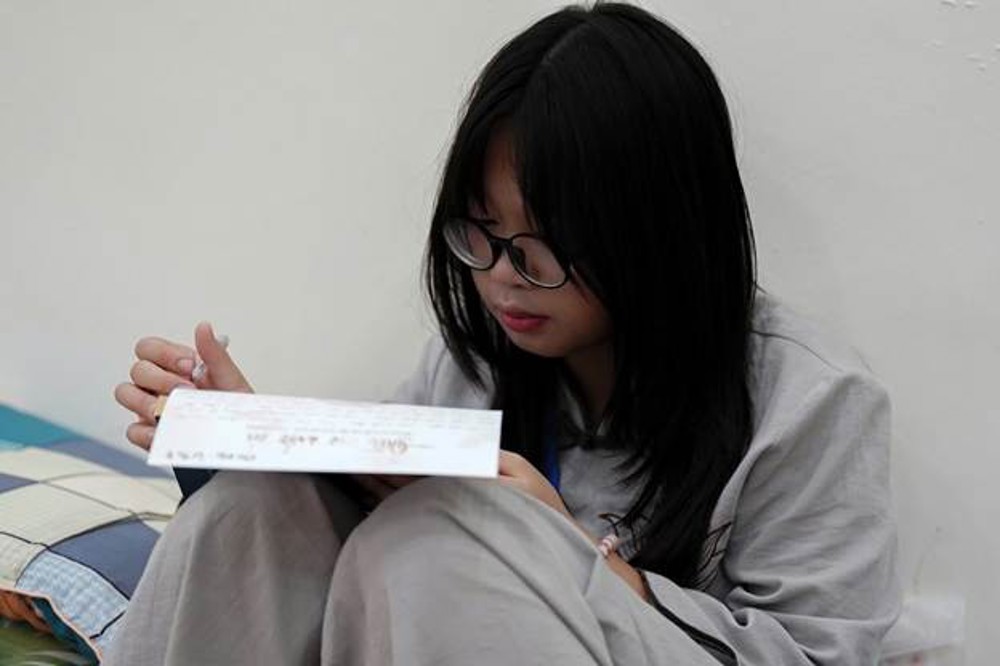 A person sitting on the floor reading a letter

AI-generated content may be incorrect.