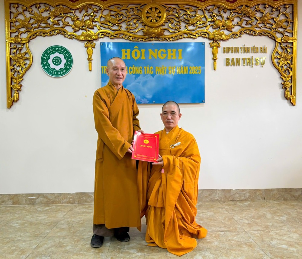 Two men in orange robes holding a red book

AI-generated content may be incorrect.